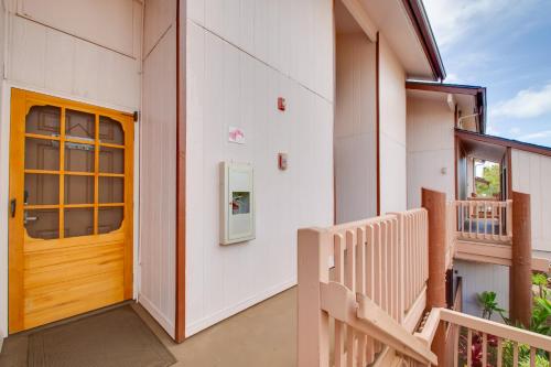 a house with a wooden door and a balcony at Saltwater Pool Access Lihue Gem Near Bar and Grill! in Lihue