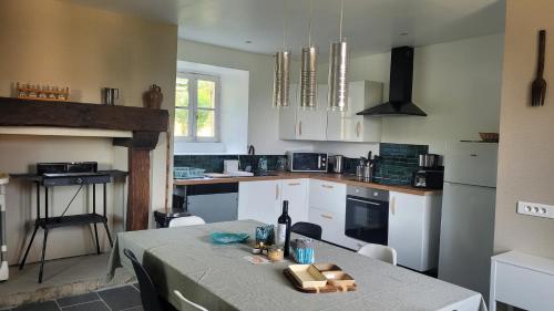 a kitchen with a table with a bottle of wine on it at Maison Tiny Bwa in Saint-Cernin-de-lʼHerm