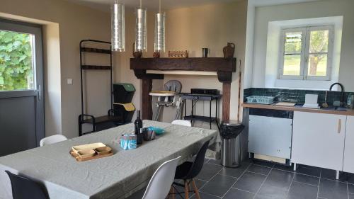 a kitchen with a table with chairs and a tableasteryasteryasteryasteryasteryastery at Maison Tiny Bwa in Saint-Cernin-de-lʼHerm