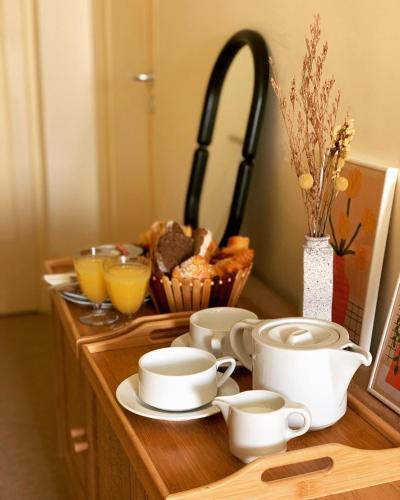 a wooden counter with cups and plates and a sink at Hôtel La Boulangerie in Grimaud