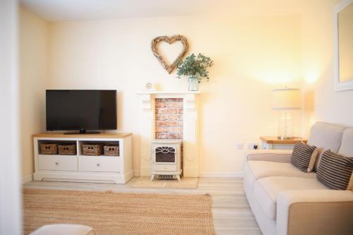 a living room with a couch and a flat screen tv at Ffordd Y Meillion in Llanelli