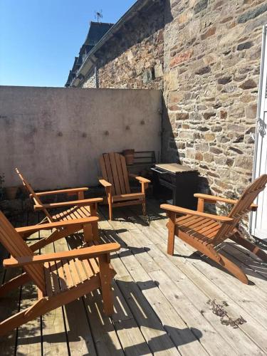un gruppo di sedie di legno sedute su un patio di Ti Yoco a Ploubazlanec