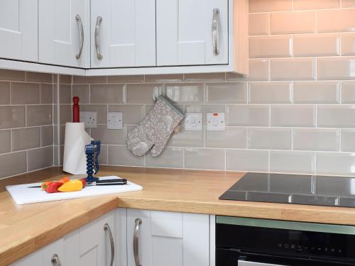 a kitchen with white cabinets and a counter top at Glasfor in Llanon