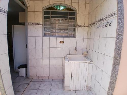 サン・ベント・ド・サプカイーにあるCasa Descanso São Bento Sapucaíのタイル張りのバスルーム(シンク、窓付)