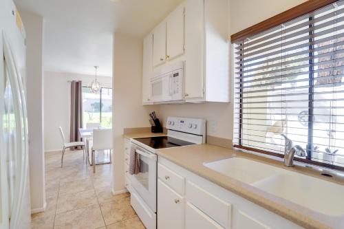 a kitchen with white cabinets and a sink and a window at Furnished Patio and Mtn View Palm Desert Retreat in Palm Desert