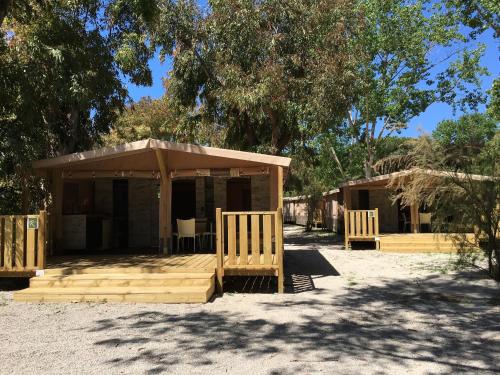a small building with two benches in front of it at Camping Village Rocchette in Castiglione della Pescaia