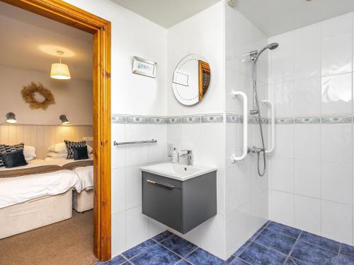 a bathroom with a sink and a shower and a bed at Paradise in Gisburn