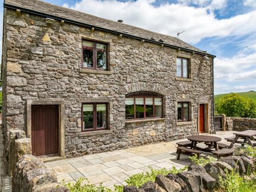a stone cottage with a picnic table and a picnic table at Paradise in Gisburn