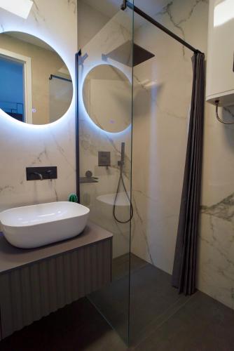 a bathroom with a sink and a glass shower at Boutique Spa Studioapartment IV in Opatija