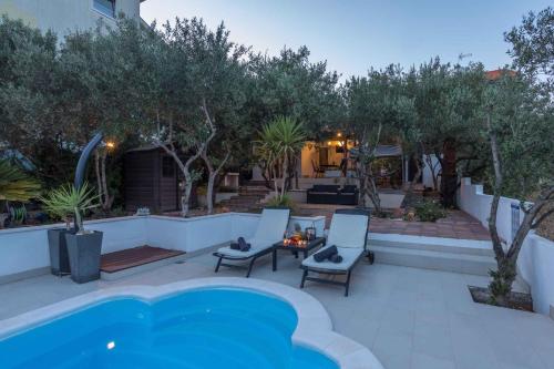 a backyard with a pool and chairs and trees at Holiday home Stari Grad - Insel Hvar 6341 in Stari Grad