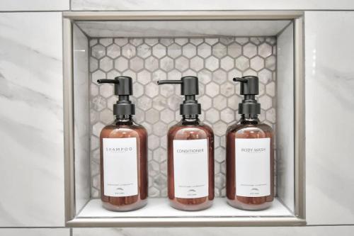 three bottles of soap in a bathroom shelf at Cozy Houston Haven-Near Downtown & NRG in Houston