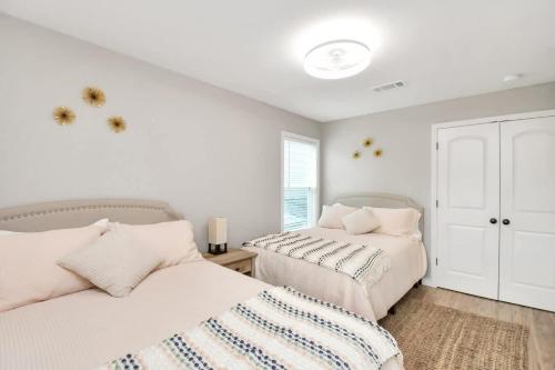 two beds in a bedroom with white walls at Cozy Houston Haven-Near Downtown & NRG in Houston