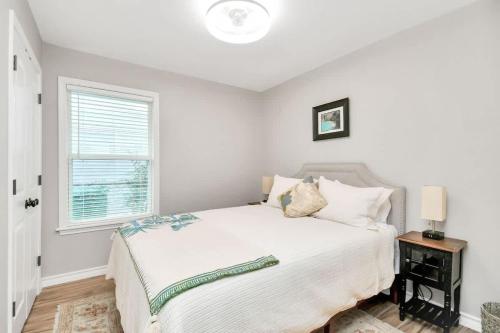 a white bedroom with a bed and a window at Cozy Houston Haven-Near Downtown & NRG in Houston