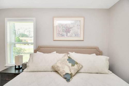 a white bedroom with a bed with white pillows at Cozy Houston Haven-Near Downtown & NRG in Houston
