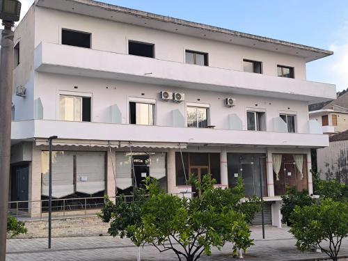 a white building with trees in front of it at Delvina Central Rooms by Mira in Delvinë