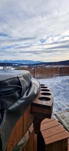 a hot tub sitting on top of a snow covered deck at Babiogórskie Domki in Lipnica Wielka