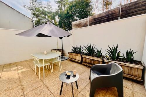 un patio avec une table, des chaises et un parasol dans l'établissement T2 with terrace near Les Minimes, à La Rochelle