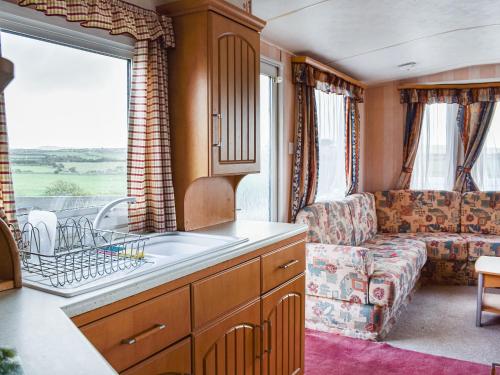 a kitchen and living room with a couch and a sink at Methlem in Aberdaron