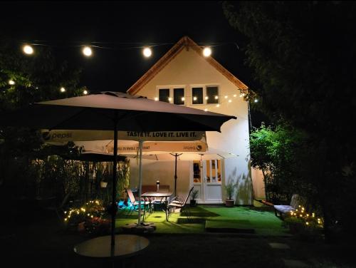a house with a table and an umbrella at night at Forest Inn in Izvorani