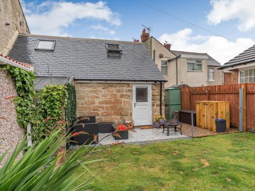 a backyard with a brick house and a fence at The Old Wash House in Amble