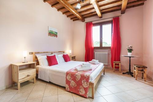 a bedroom with a large bed with red curtains at Masseria Le Querciole in Fauglia