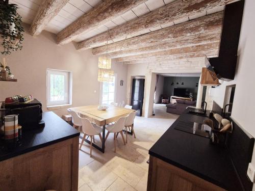 une cuisine et une salle à manger avec une table et des chaises dans l'établissement Sublime Mas de Lou à 15 minutes d'Arles, à Tarascon
