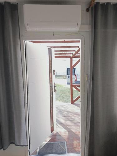 an open door to a porch with a view of a house at Pod orzechem in Osieki