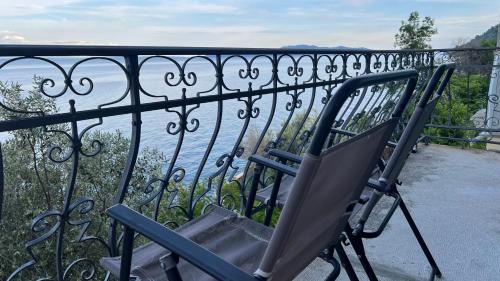 a chair sitting on a balcony overlooking the water at Sea whisper in Lovran