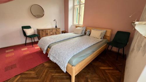 a bedroom with a bed with two chairs and a mirror at Sea whisper in Lovran
