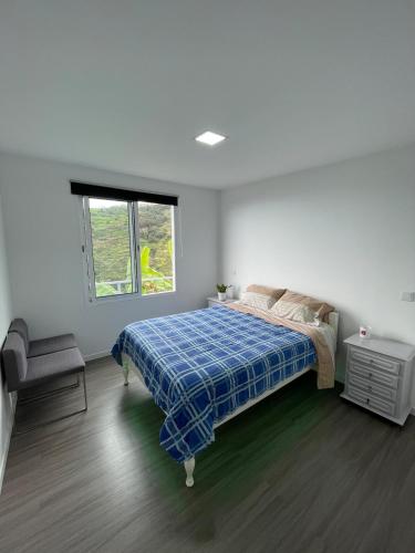 una camera da letto bianca con un letto e una finestra di Charming hill view retreat a Funchal