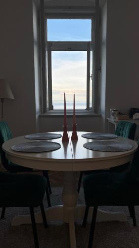 a dining room table with chairs and a window at Sea whisper in Lovran