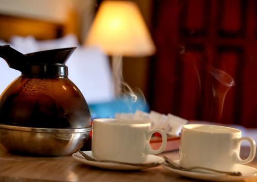 two coffee cups and a kettle on a table at Sangrilla Bandarawela in Bandarawela