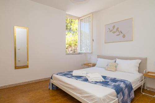 a bedroom with a bed with a mirror and a window at Casa Vacanze - Platamò in Platamona