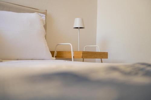 a bedroom with a bed and a table with a lamp at Casa Vacanze - Platamò in Platamona