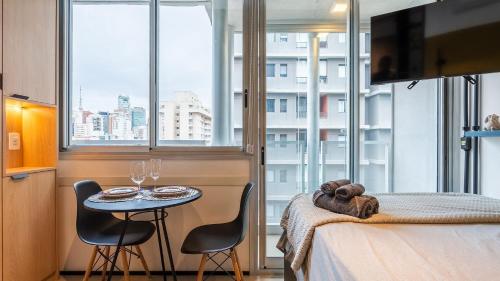 una camera con un letto e un tavolo con due sedie di Studios luxuosos ao lado do Shooping Frei Caneca a San Paolo