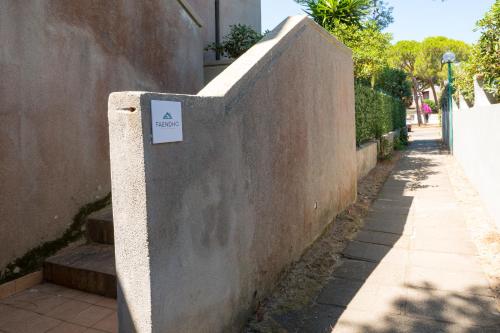 a wall with a sign on it next to a sidewalk at Casa Vacanze - Platamò in Platamona