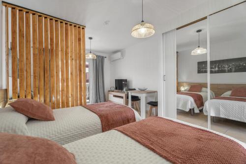 a hotel room with two beds and a mirror at Parque Carolina 207 in Costa Del Silencio