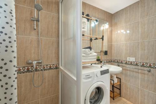a bathroom with a washing machine and a shower at Parque Carolina 207 in Costa Del Silencio