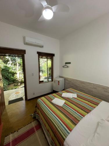 a bedroom with a large bed and a window at Pousada Cachoeira in Abraão