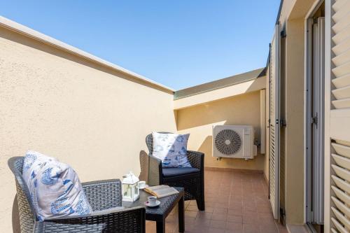 a patio with two chairs and a table and a heater at Italian Experience-Sweet Conero in Porto Recanati