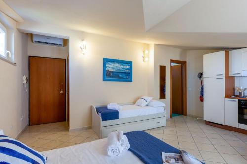 a bedroom with two beds and a kitchen at Italian Experience-Sweet Conero in Porto Recanati