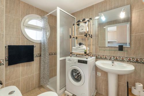 a bathroom with a washing machine and a sink at Parque Carolina 208 in Costa Del Silencio