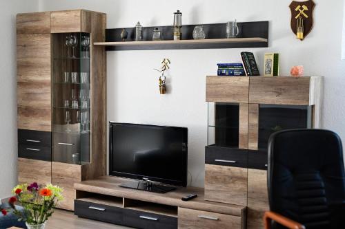 a living room with a entertainment center with a television at Ferienwohnung Zum Steiger in Bleicherode