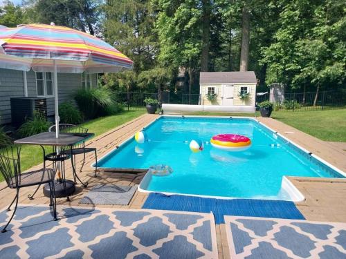 a swimming pool with an umbrella and a frisbee in it at 597b) Large 4 bedroom - Pool - Fire Pit in Wolcott