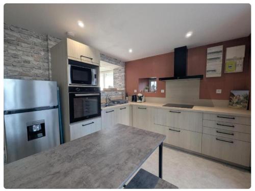a kitchen with a stainless steel refrigerator and a table at O'bocolecha in Orges