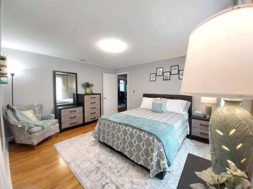 a bedroom with a bed and a chair and a mirror at 597b) Large 4 bedroom - Pool - Fire Pit in Wolcott