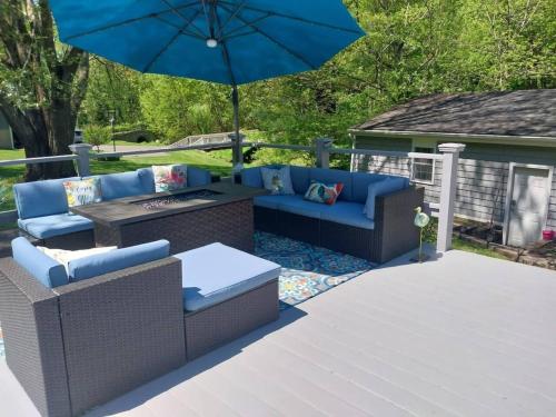 a patio with couches and a table and an umbrella at 597b) Large 4 bedroom - Pool - Fire Pit in Wolcott