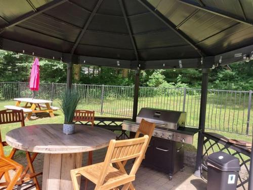 a patio with a table and a grill at 597b) Large 4 bedroom - Pool - Fire Pit in Wolcott