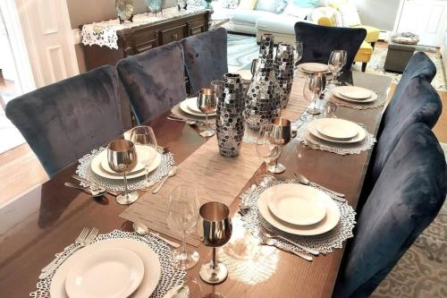 a dining room table with plates and wine glasses at 597b) Large 4 bedroom - Pool - Fire Pit in Wolcott