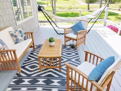 a porch with chairs and a table and a hammock at 597b) Large 4 bedroom - Pool - Fire Pit in Wolcott
